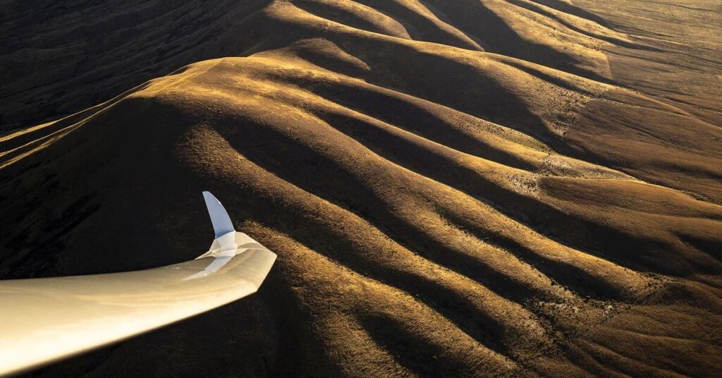 sailplane left wing and mountain ridge